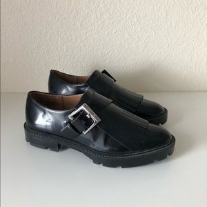 Black Zara loafers with buckle and fringe detail.